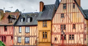 Investir dans l'immobilier au Mans L'image montre des maisons à colombages dans le centre historique de la ville du Mans. 