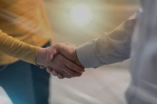 poignée de main dans une ambiance chaleureuse symbolisant le choix d'un courtier en prêt immobilier