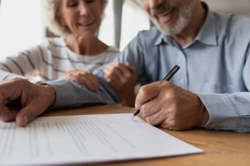 un couple de senior est heureux de signer un contrat qui va leur permettre de bénéficier de revenus locatifs