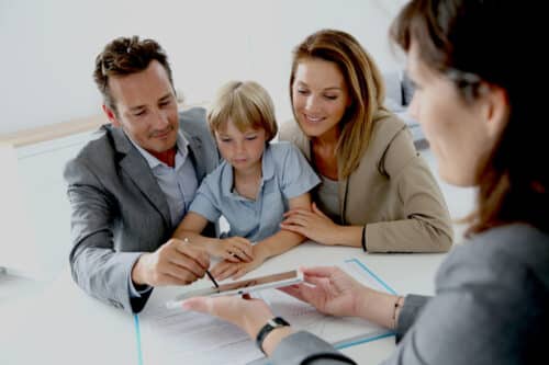 un couple de cadre en confiance et son enfant sont conseillés par une professionnelle de l'immobilier locatif