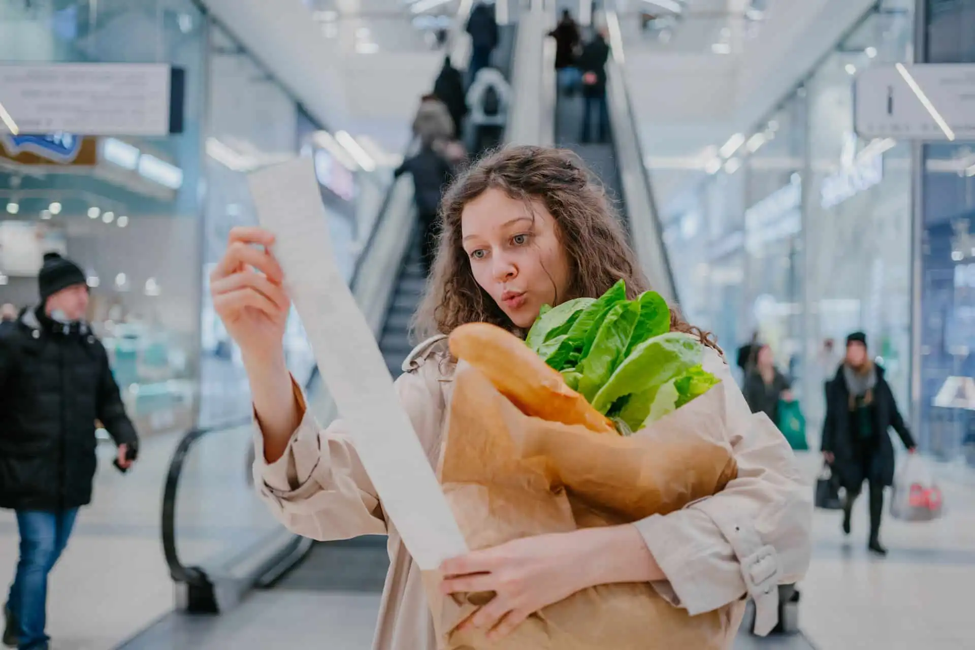 femme étonnée par l'augmentation du prix de ses courses en supermarché