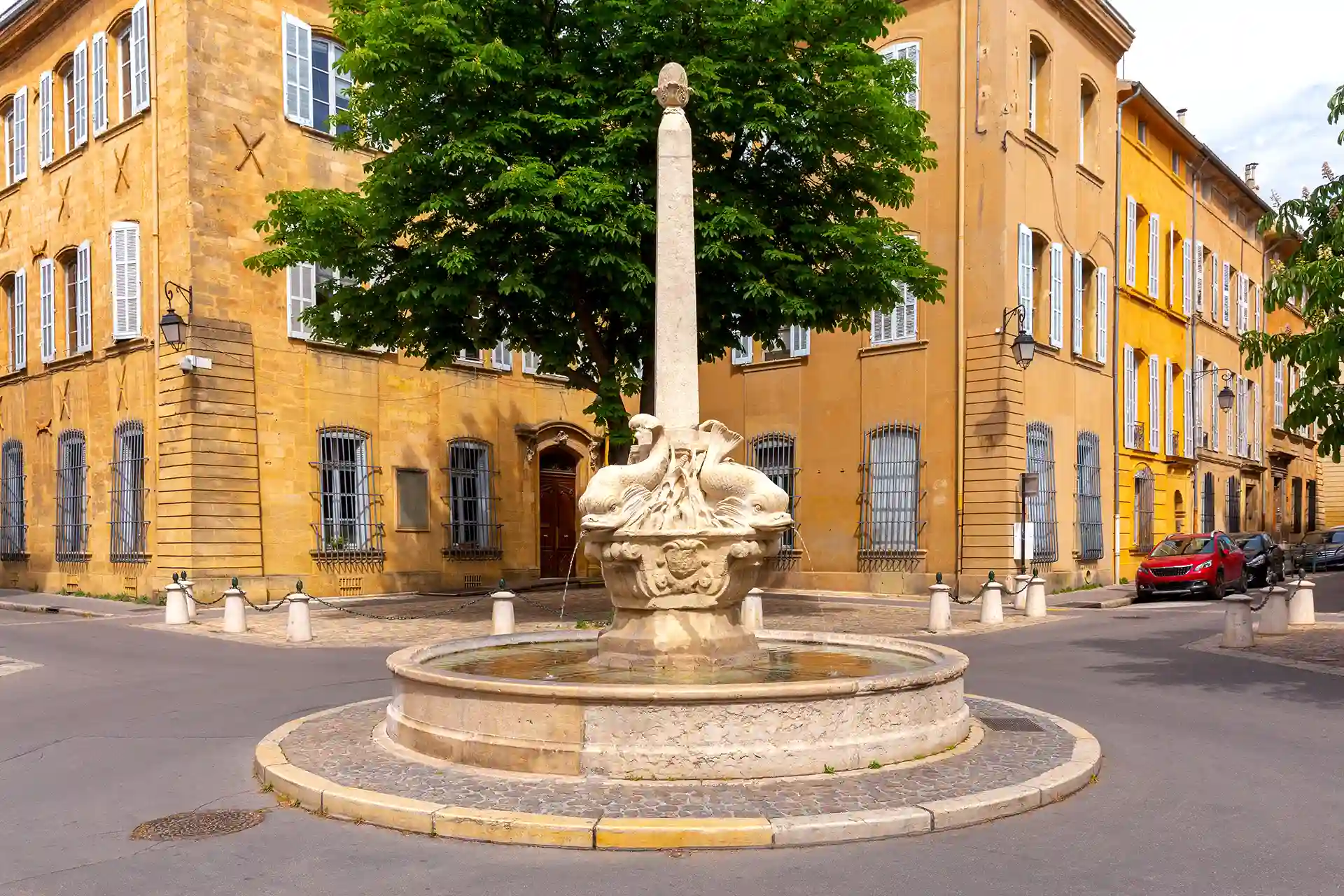 Rachat de crédits à Aix-en-Provence. L'image montre la place et la fontaine des quatre dauphins par une journée ensoleillée