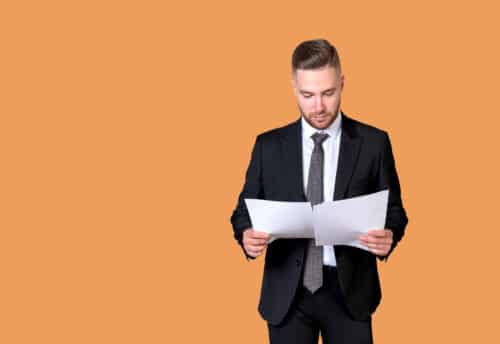 un homme en costume prend connaissance de documents