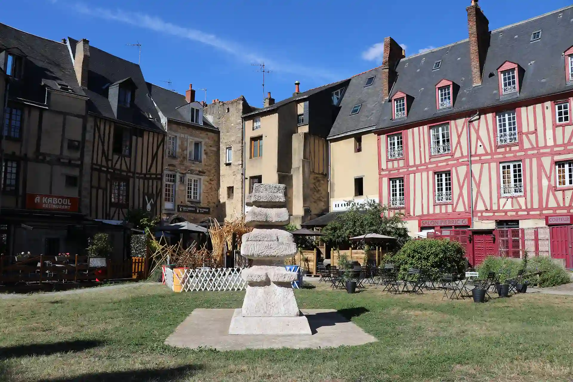 Acheter un bien immobilier pour le louer ou pour y résider en 2026. 
L'image montre la vieille ville mancelle, son architecture historique et colorée, donnant sur un parc. 