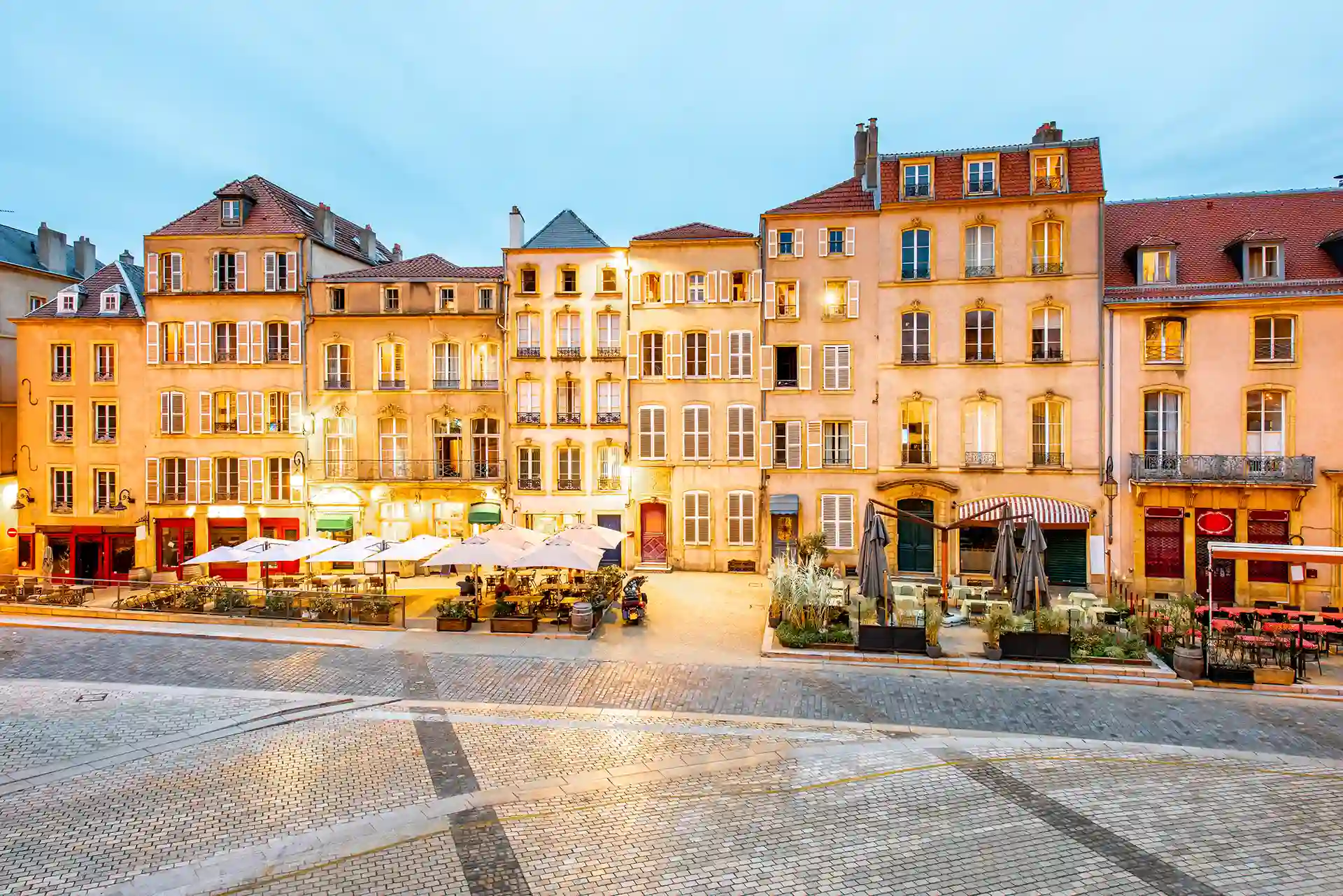 Acheter à Metz en 2026 : l'image montre des logements sur une place à la tombée de la nuit
