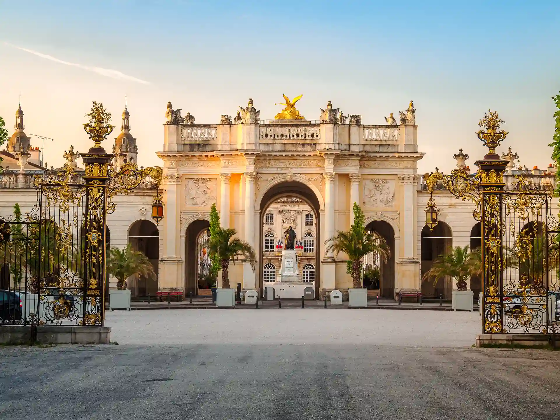 Investir dans un logement à Nancy en 2026. L’image montre la statue de Stanislas qui se trouve sur la place du même nom. Elle est vue depuis la place de la Carrière à travers l’Arc de Triomphe d’Héré.
