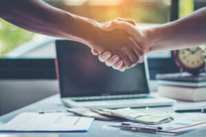 poignée de main de deux personnes signifiant une entente contractuelle de renégociation de crédt immobilier