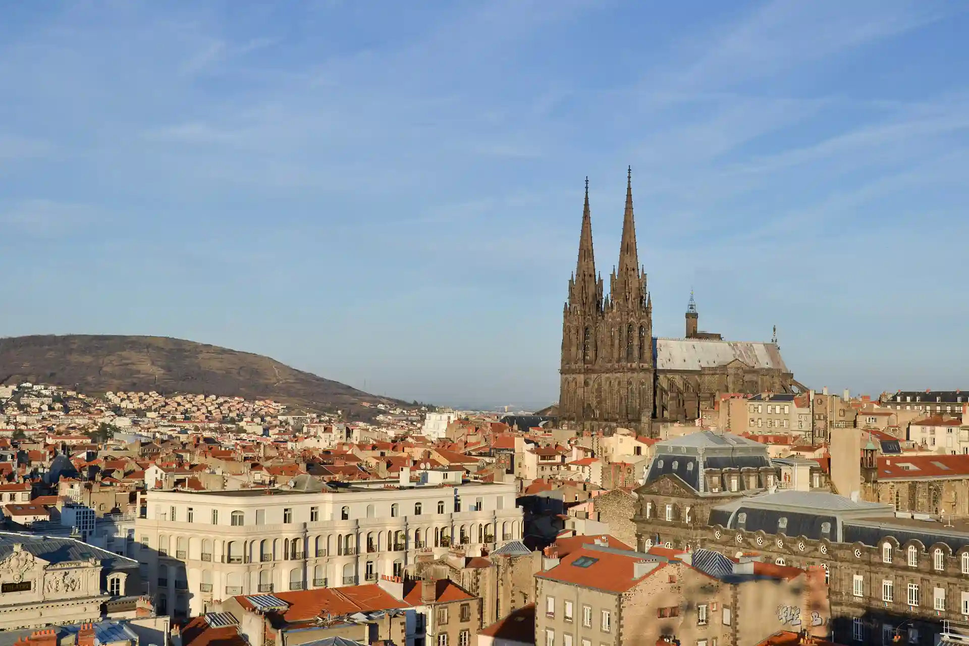 Acquérir un logement pour y vivre ou le louer à Clermont-Ferrand en 2025 plutôt qu'en 2026 ? L'image montre une vue sur la cathédrale de Clermont-Ferrand et sur une partie de la ville.